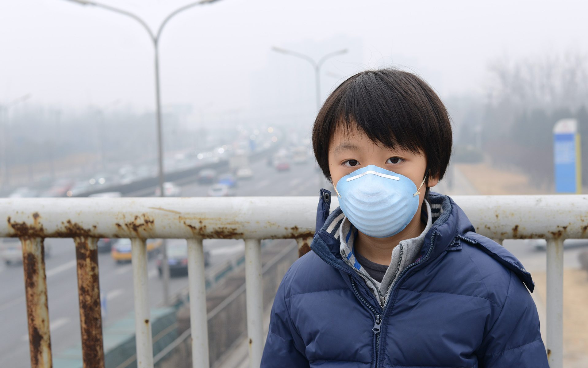 Young boy wearing filtration mask.