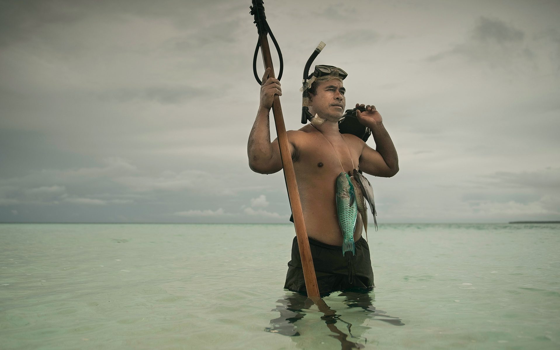 Man fishing with a snorkel and a spear.