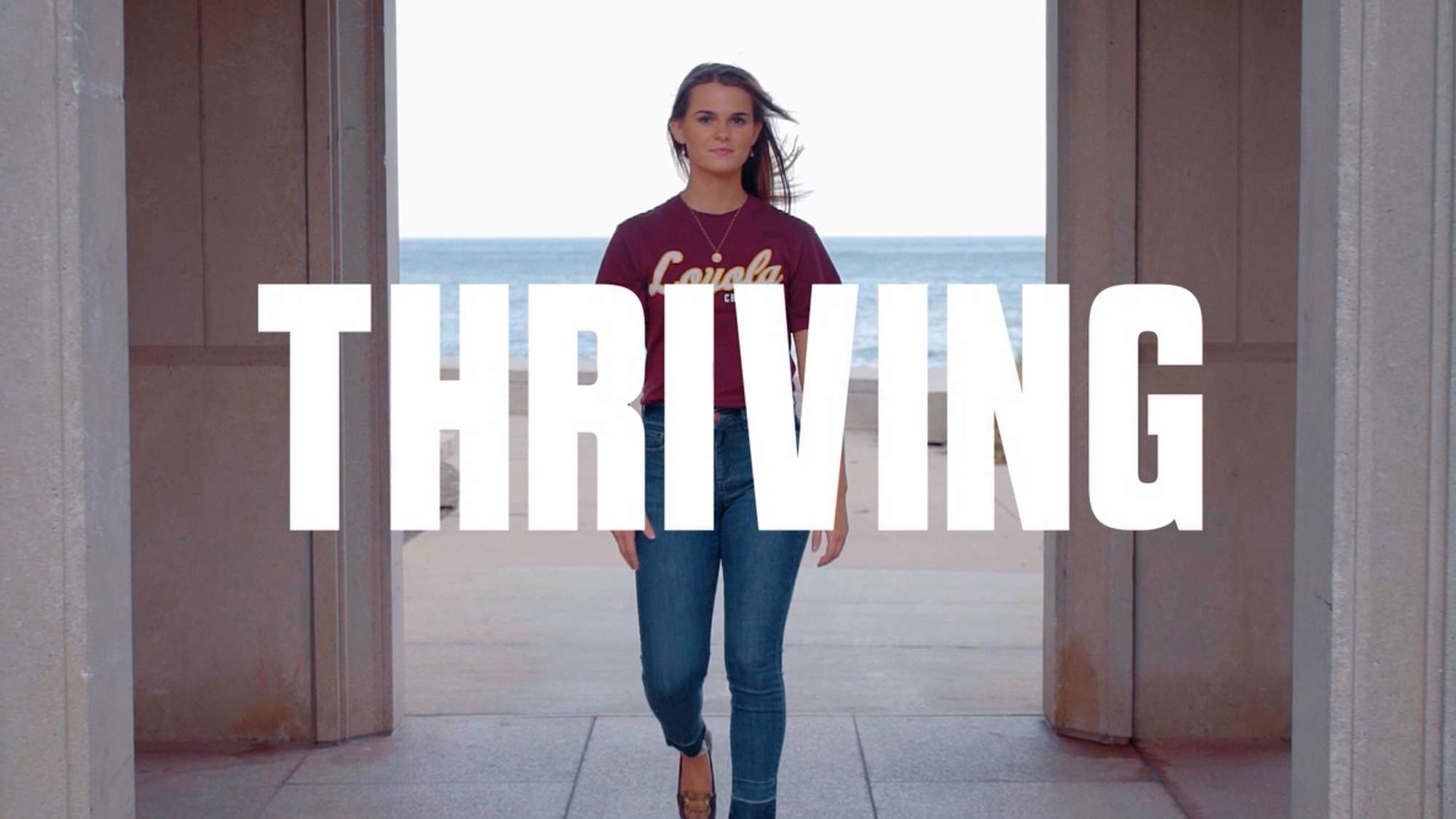 Confident college-age woman walking toward the camera. The word Thriving appears.