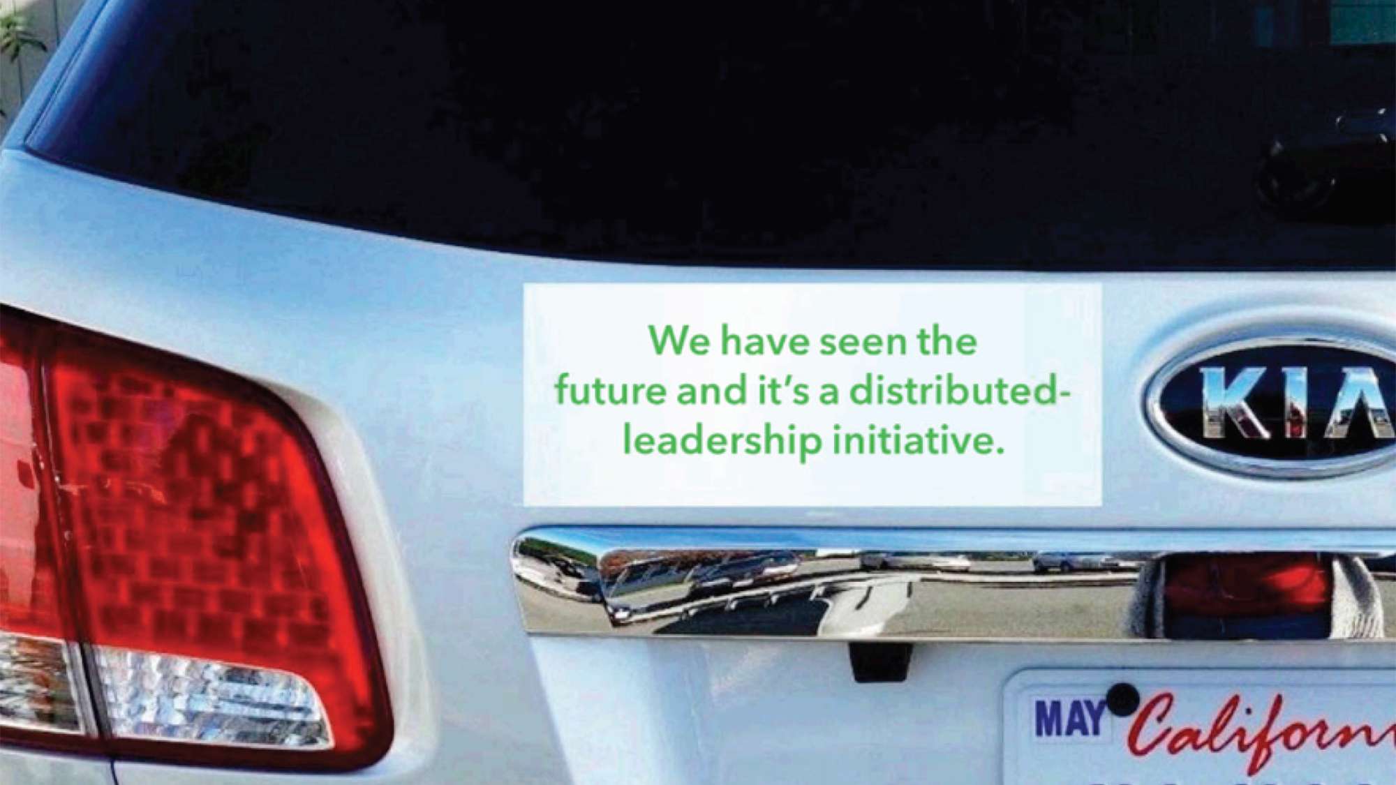 Photo of a car with a bumper sticker that reads, We have seen the future and it's a distributed-leadership initiative.